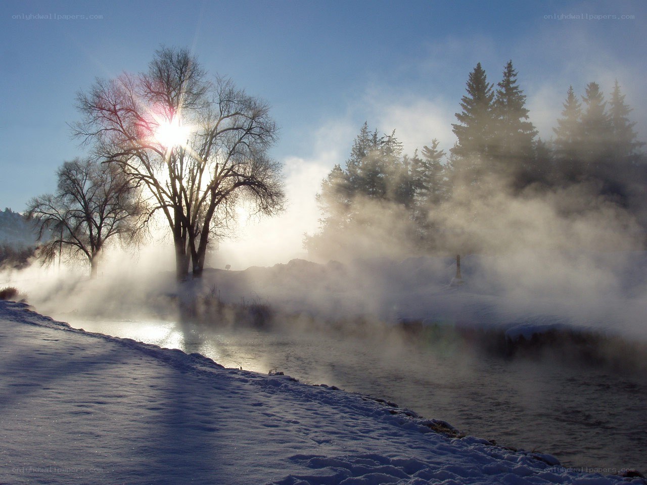 Steam rises over a snowy river