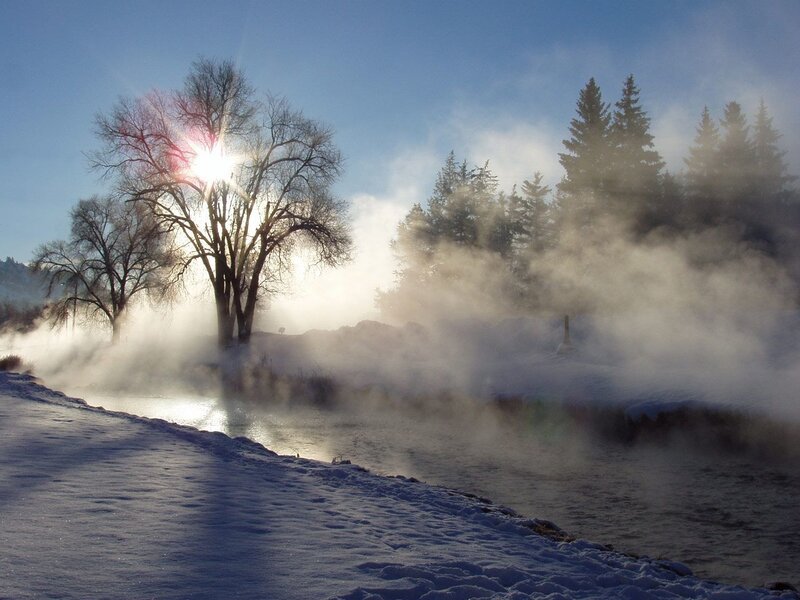 Steam rising over a snowy river