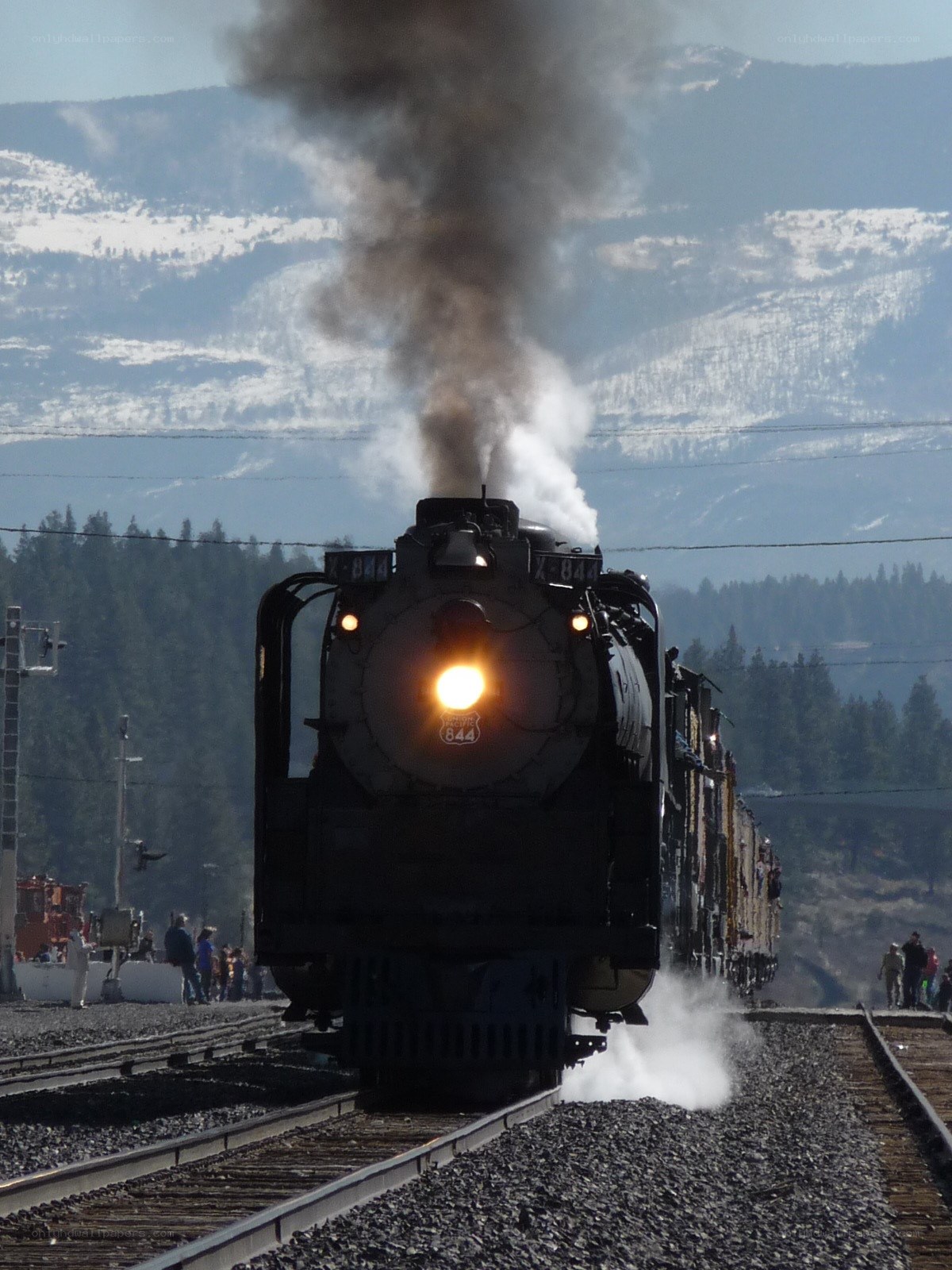 Steam train approaching on tracks
