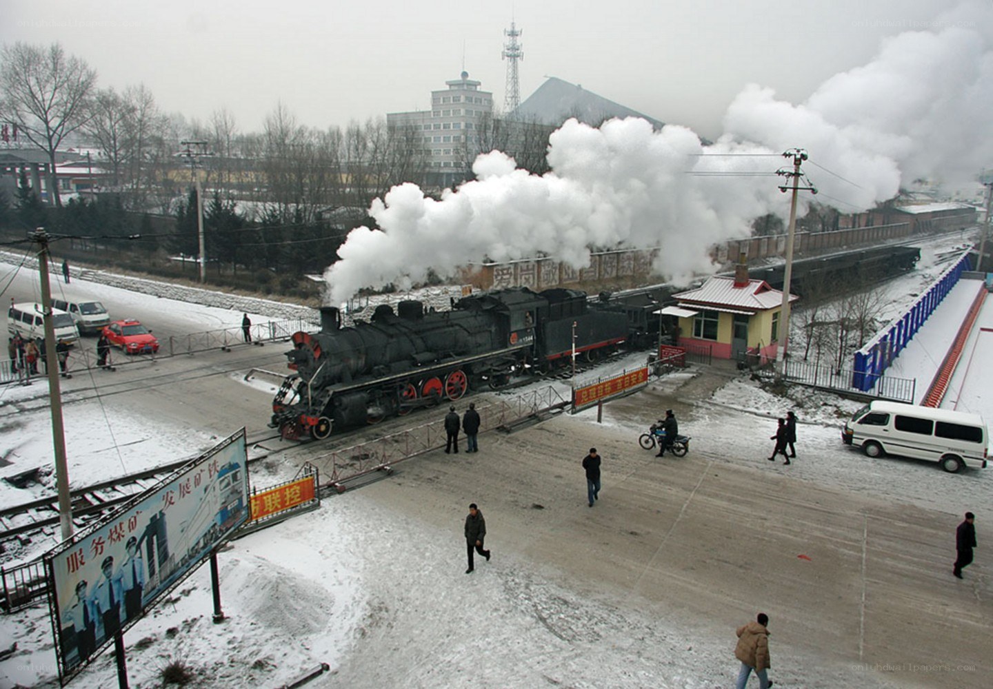 Steam train at snowy railway crossing