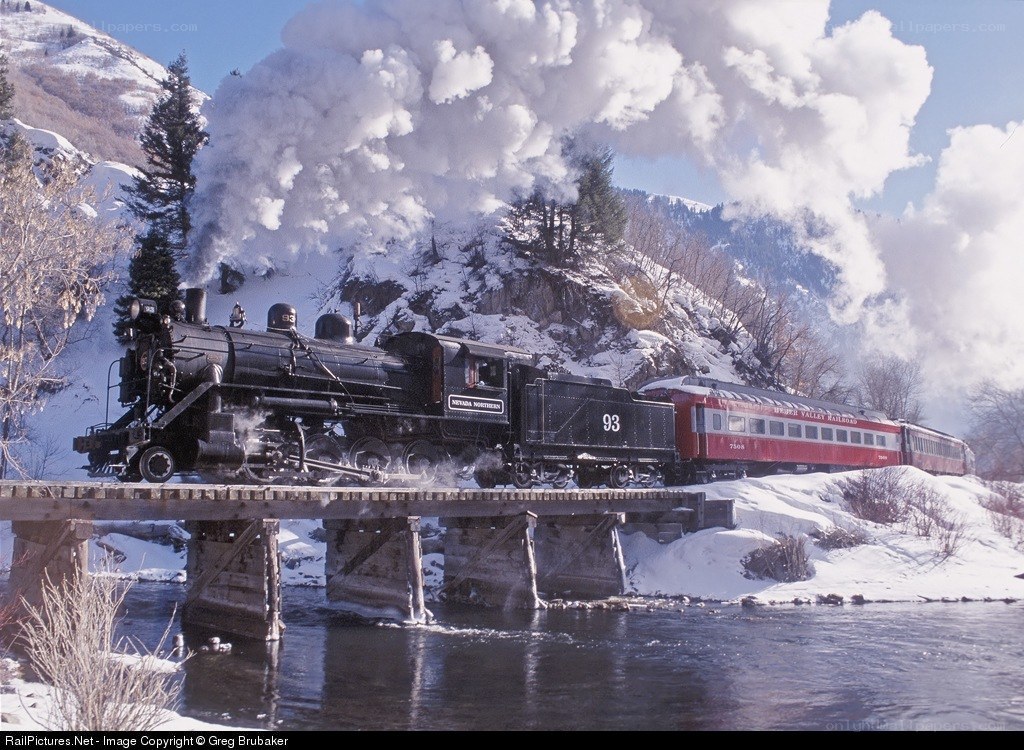 Steam train crossing bridge in winter