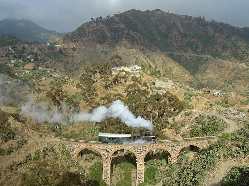 Steam train crossing mountain bridge