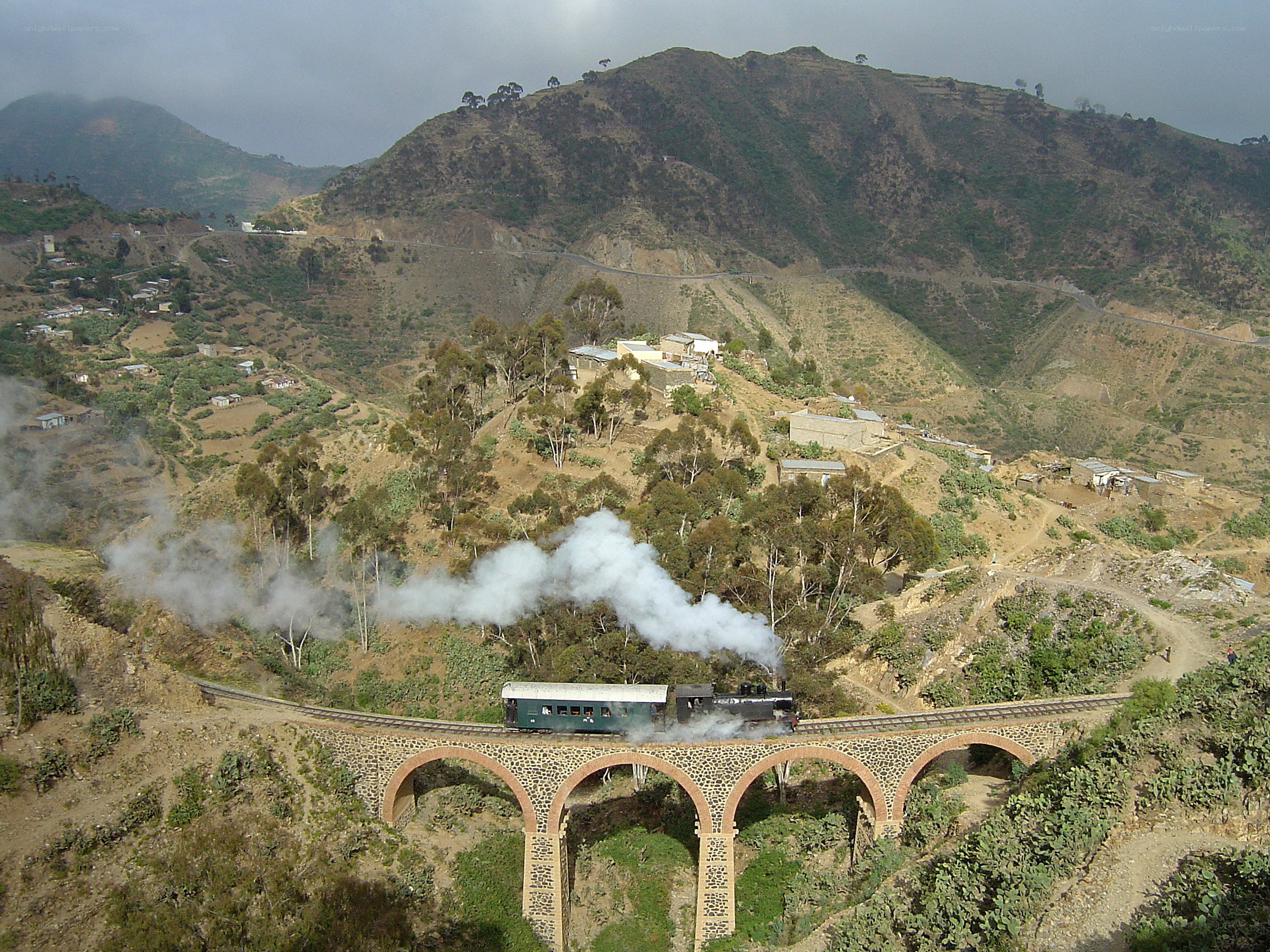 Steam train crossing mountain bridge