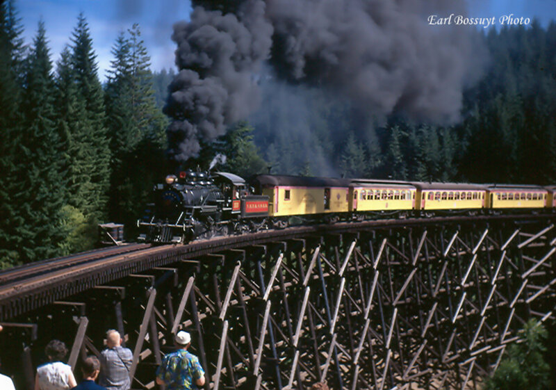 Steam train crossing trestle bridge
