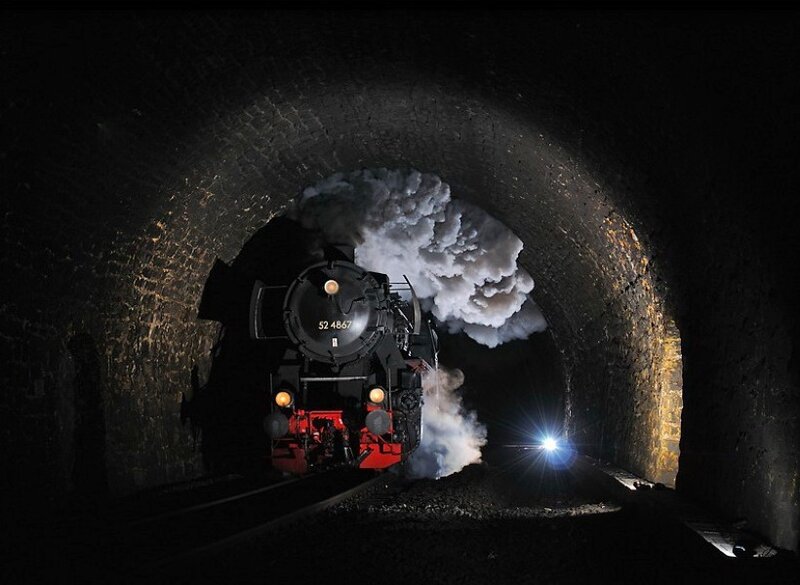 Steam train in a dark tunnel