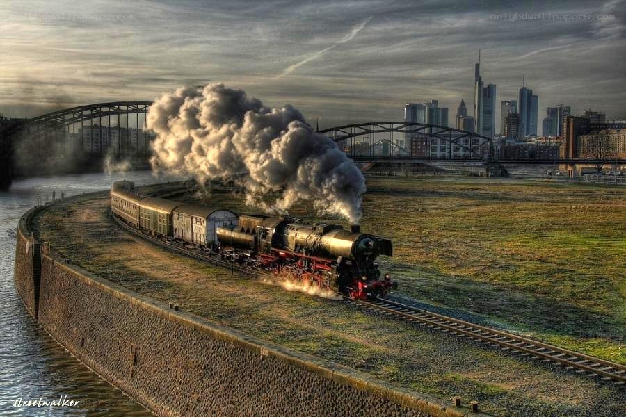Steam train near city skyline