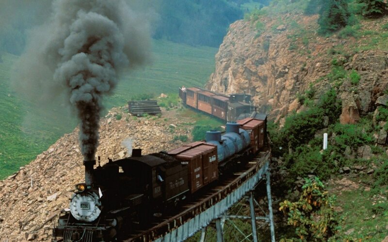 Steam train on mountain bridge