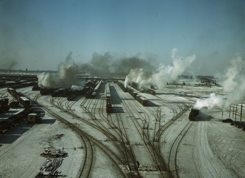 Steam trains at a snowy rail yard