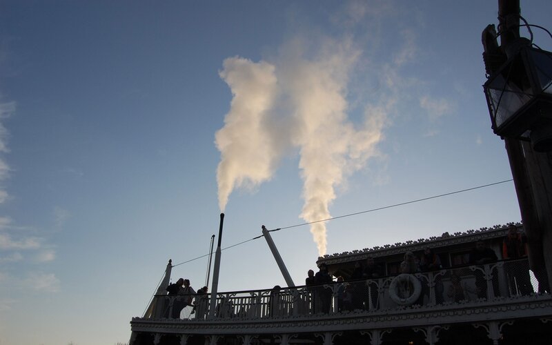 Steamboat emitting smoke at dusk