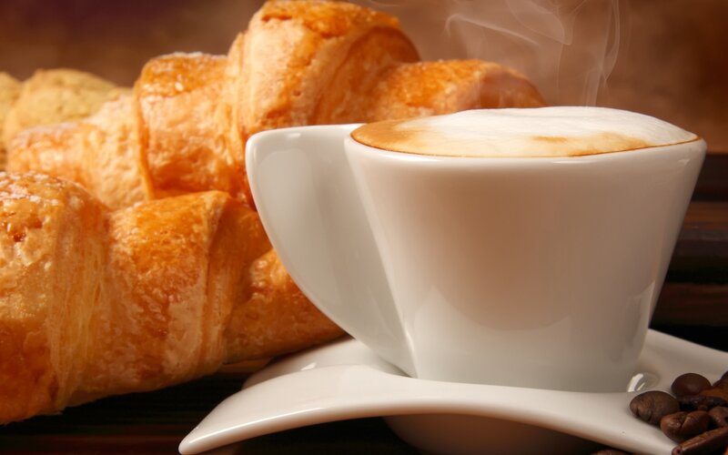 steaming cappuccino with croissants