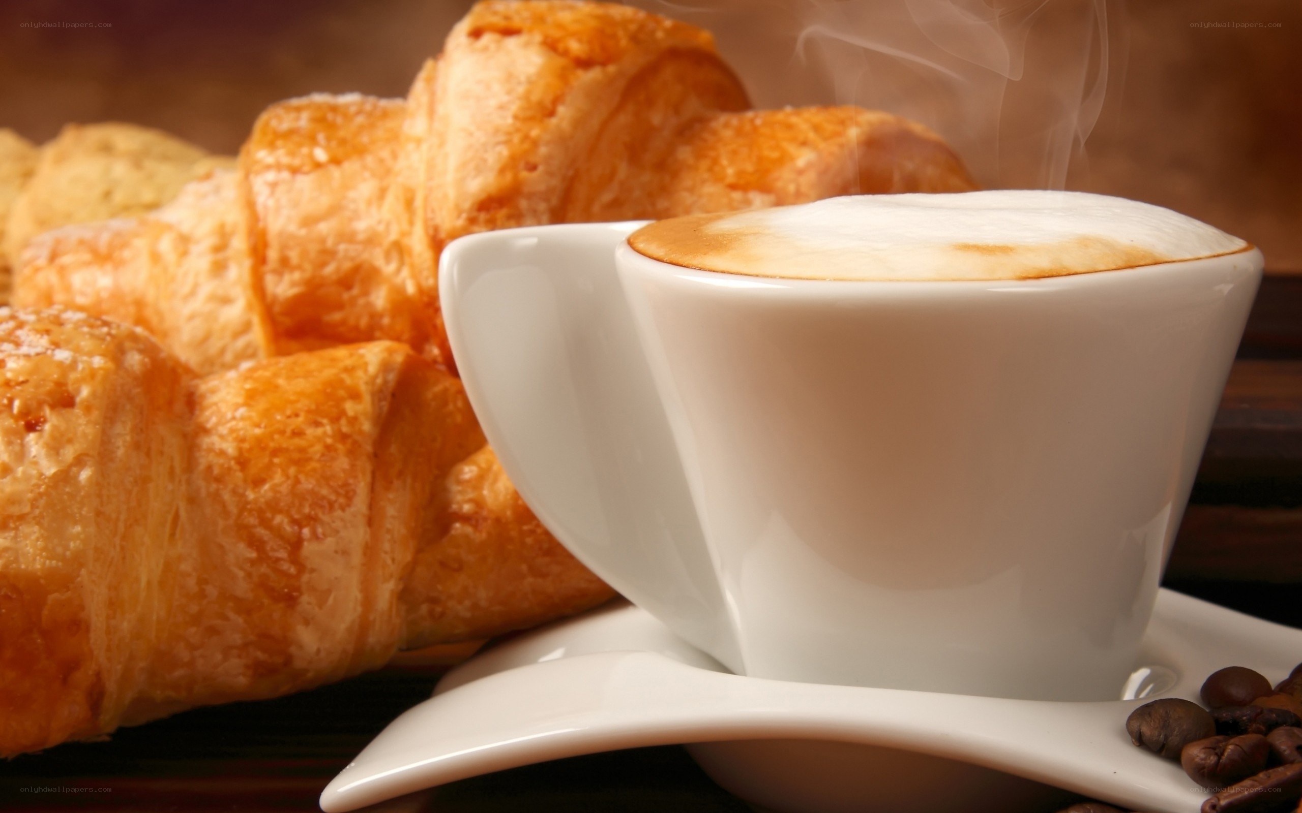 steaming cappuccino with croissants