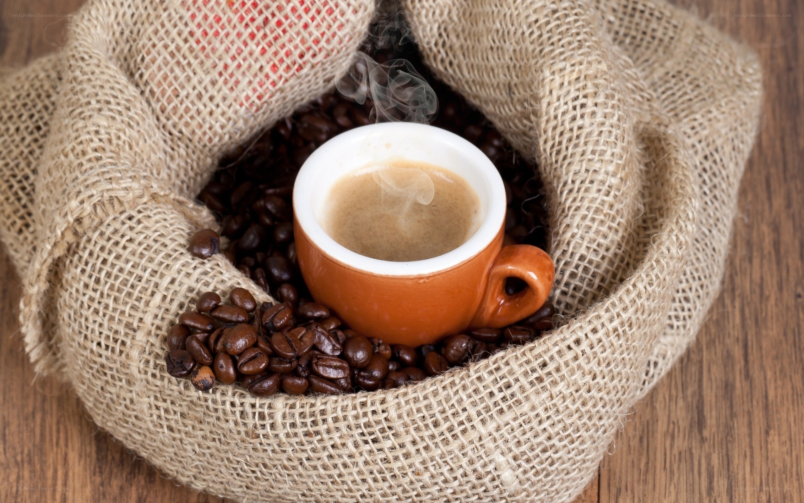steaming coffee cup in burlap sack