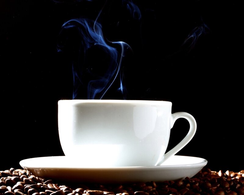 Steaming coffee cup on beans