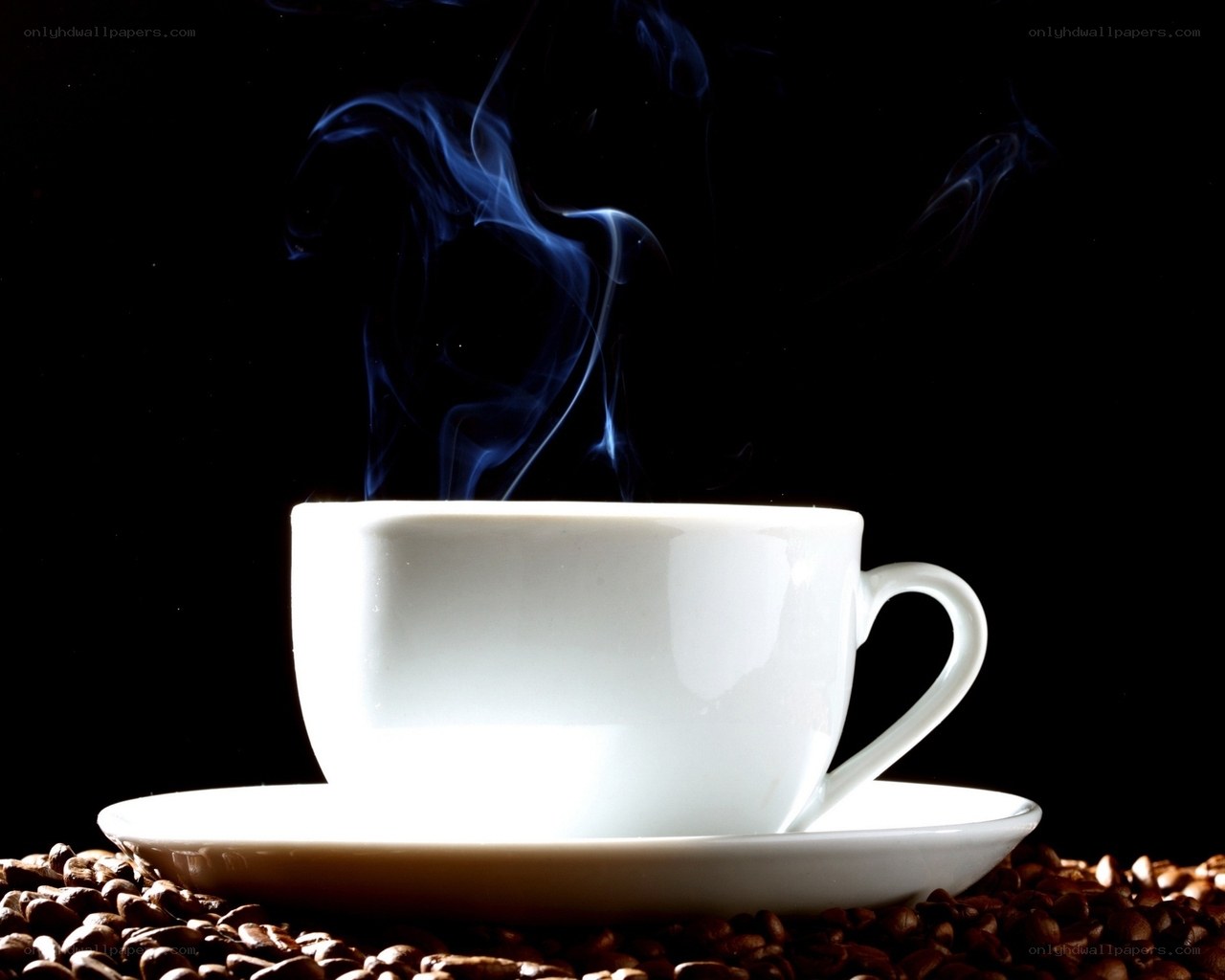 Steaming coffee cup on beans