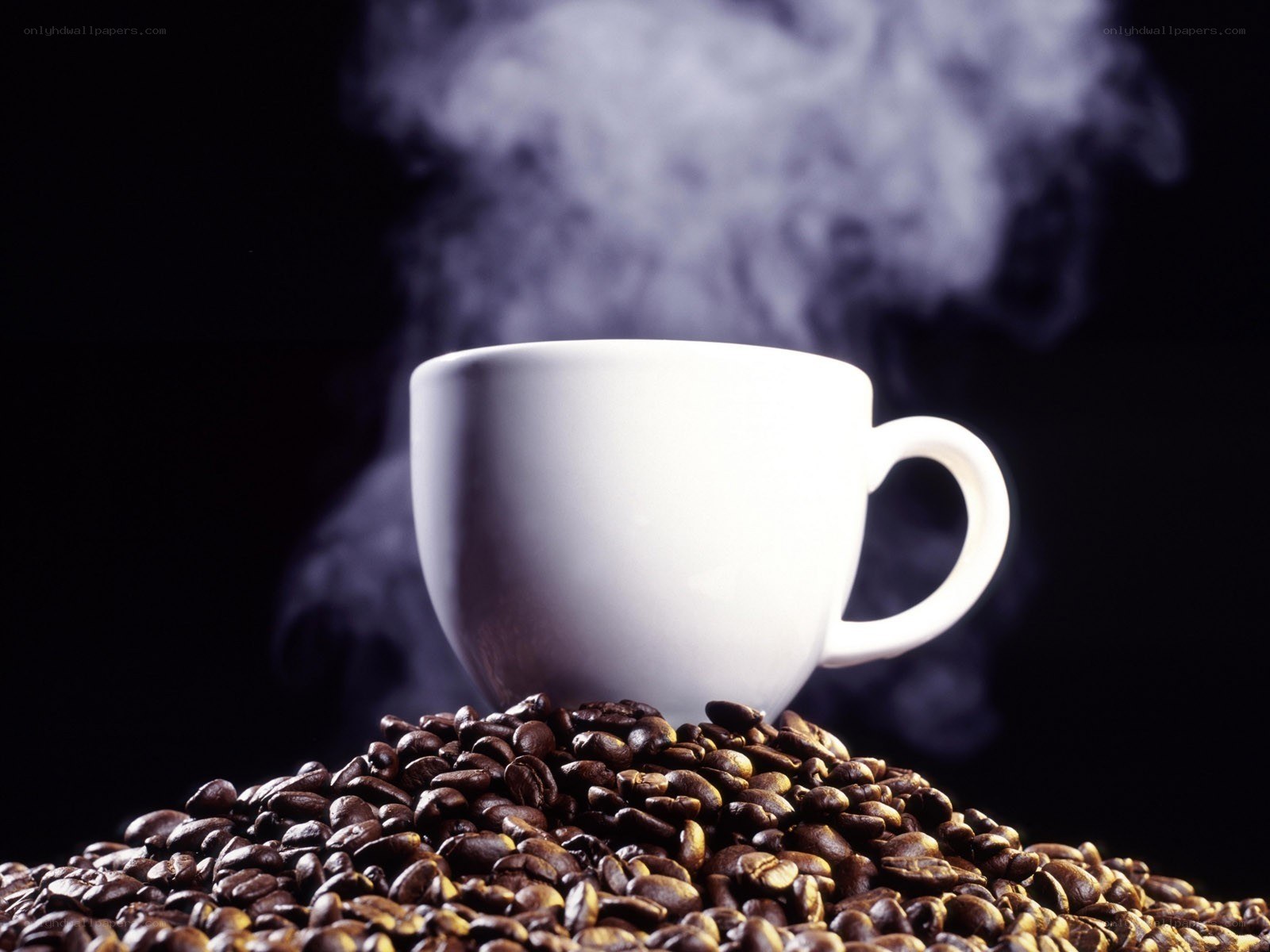 steaming coffee cup on beans