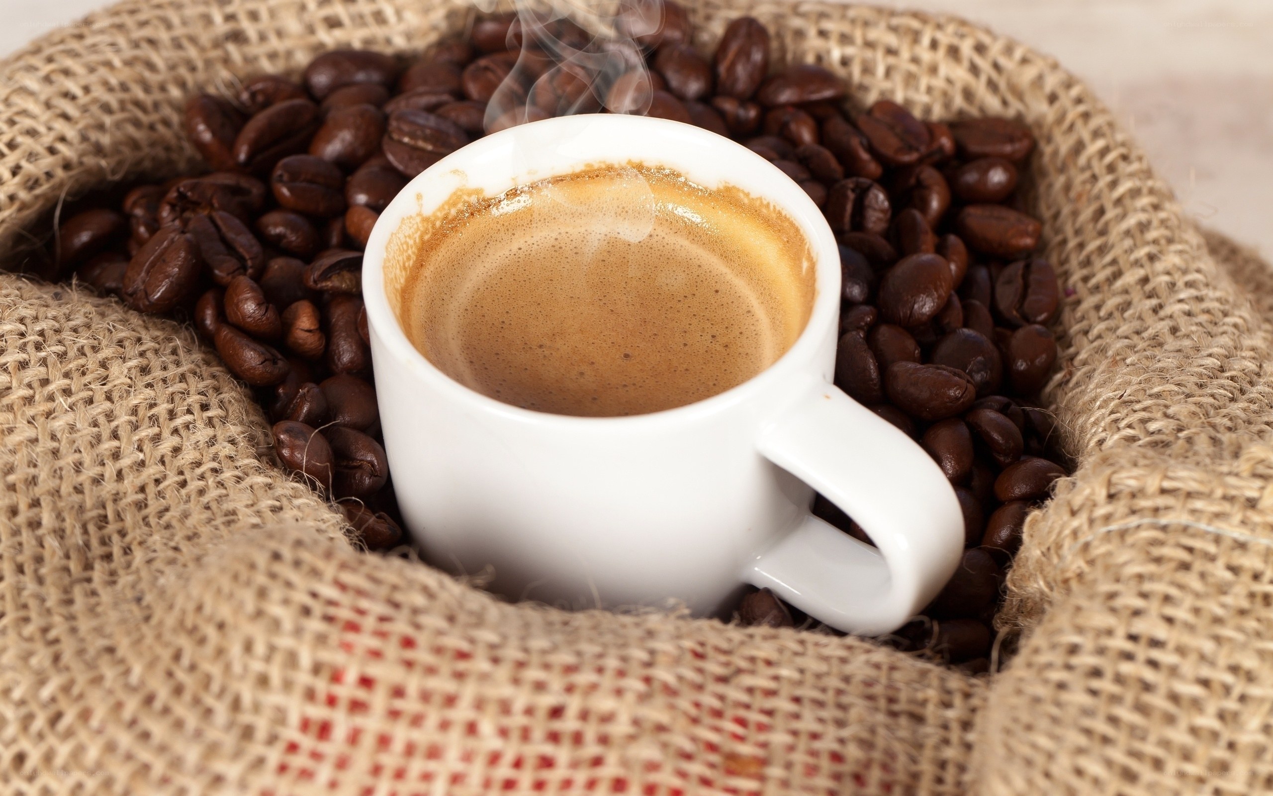 steaming coffee cup with beans