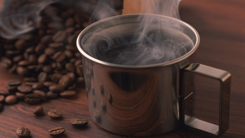 steaming coffee cup with beans