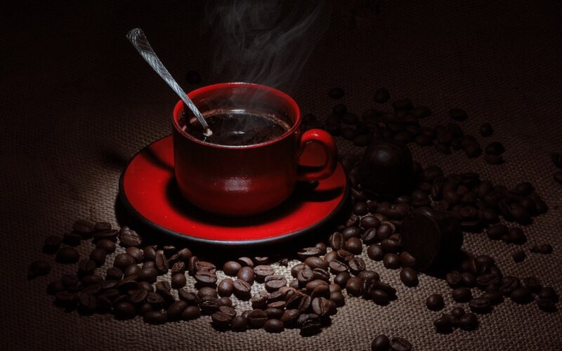 steaming coffee cup with beans
