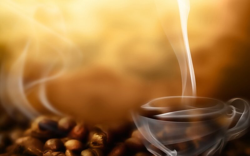 steaming coffee cup with beans