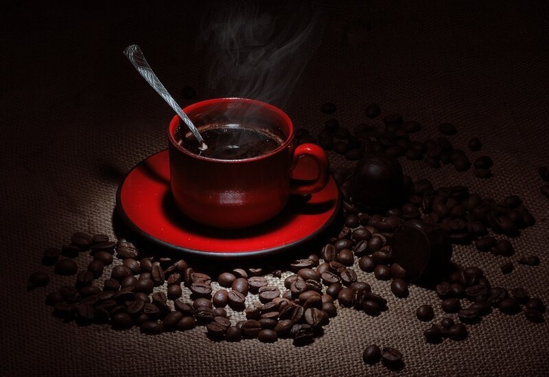 steaming coffee cup with beans