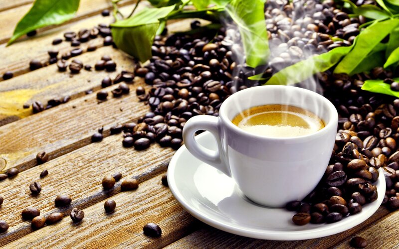 steaming coffee cup with beans