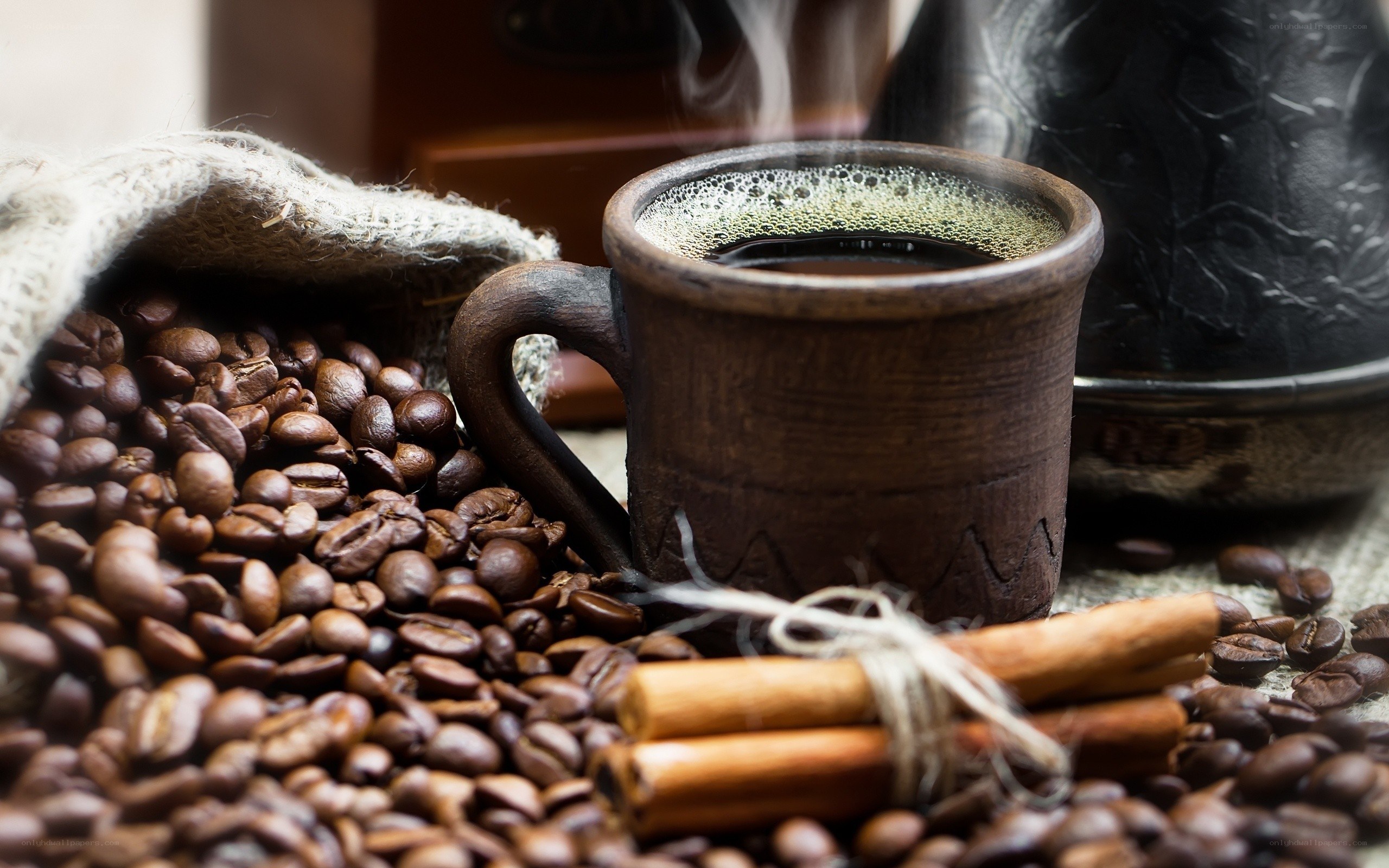 Steaming coffee with beans and cinnamon