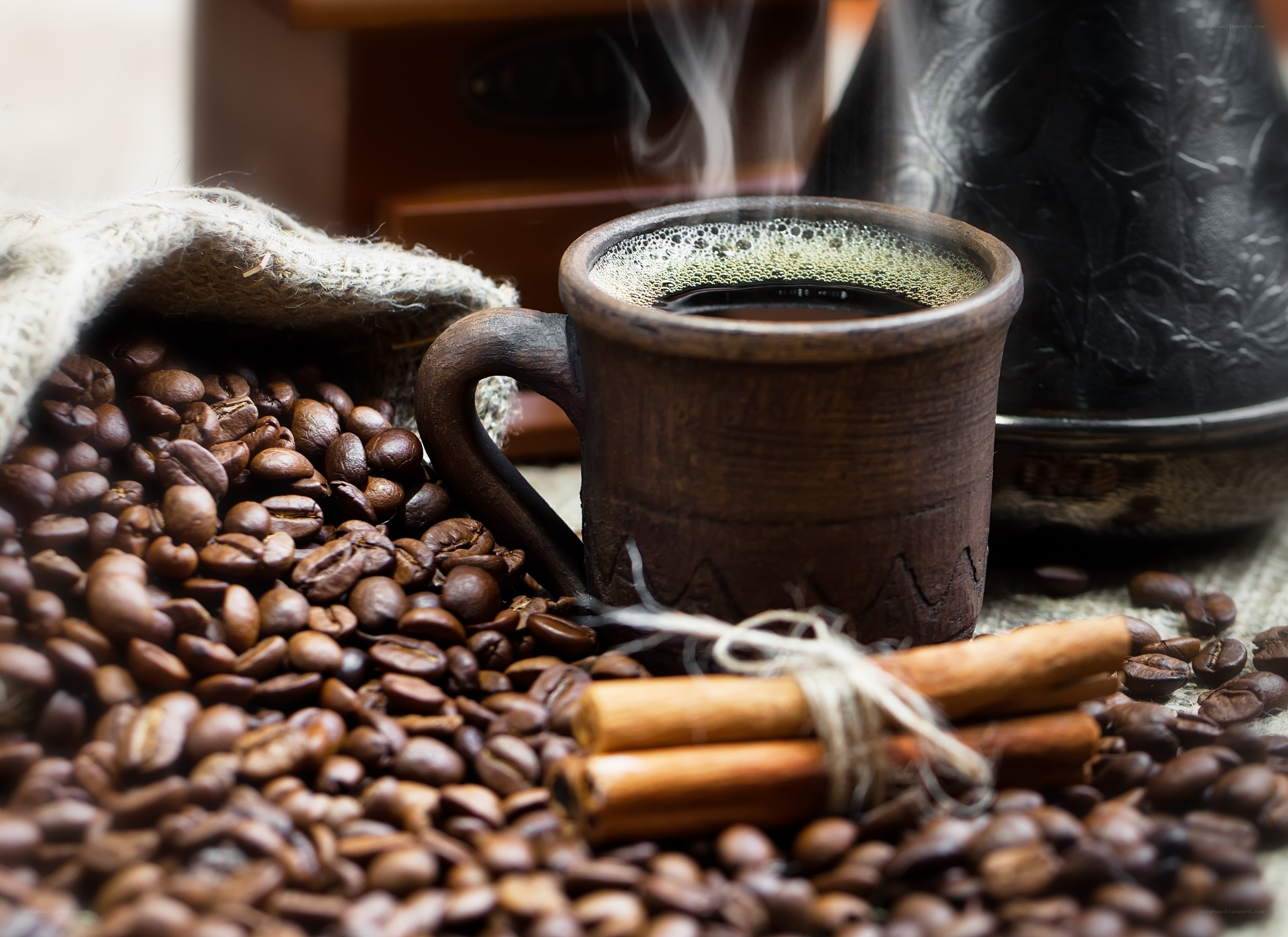 Steaming coffee with beans and cinnamon