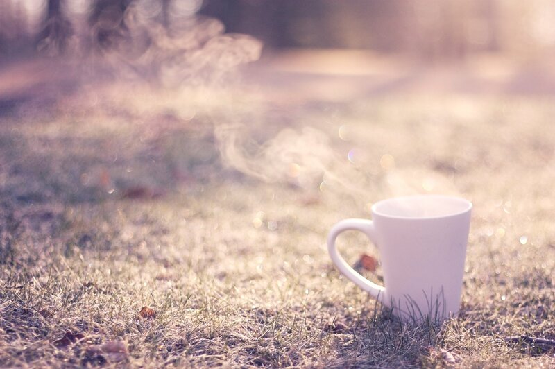 steaming mug on grass