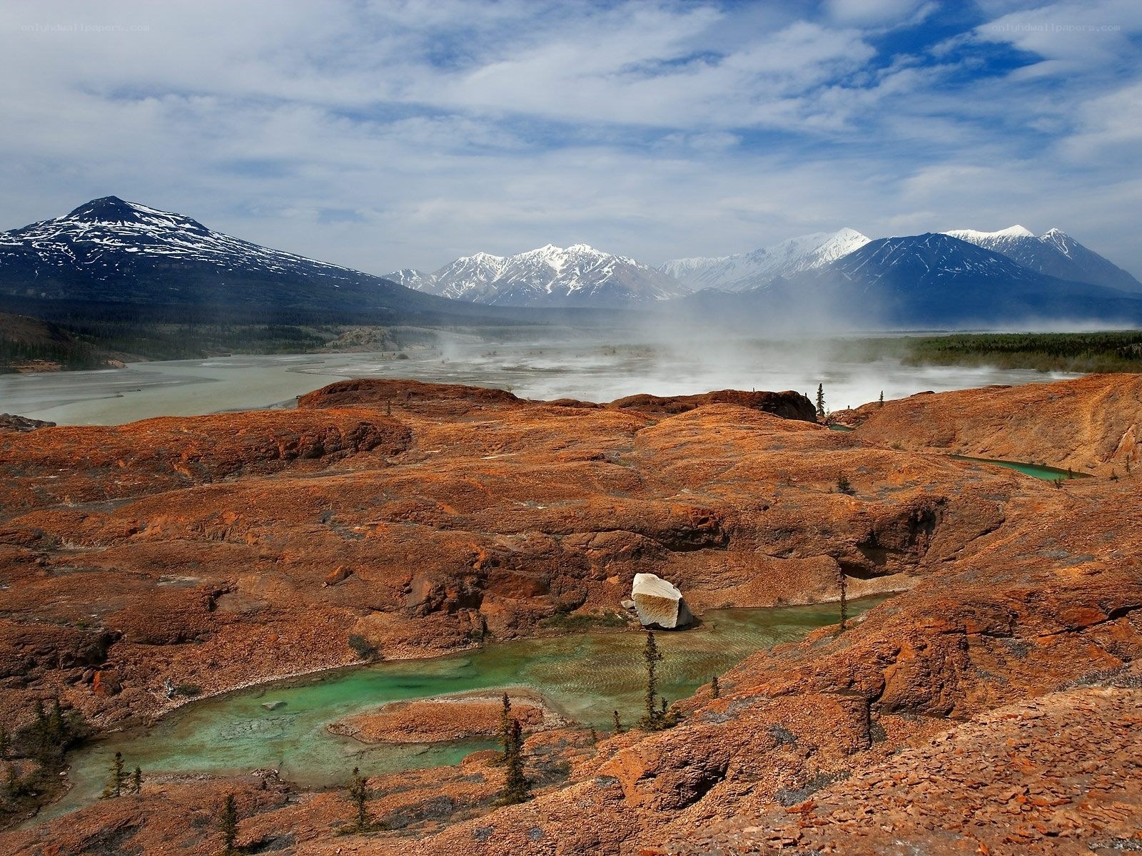 Steamy geothermal landscape with mountains