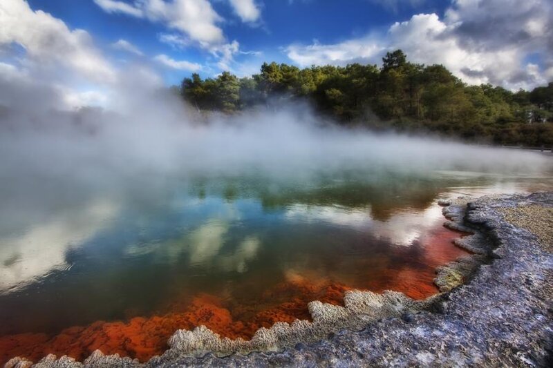 Steamy geothermal pool with colorful minerals