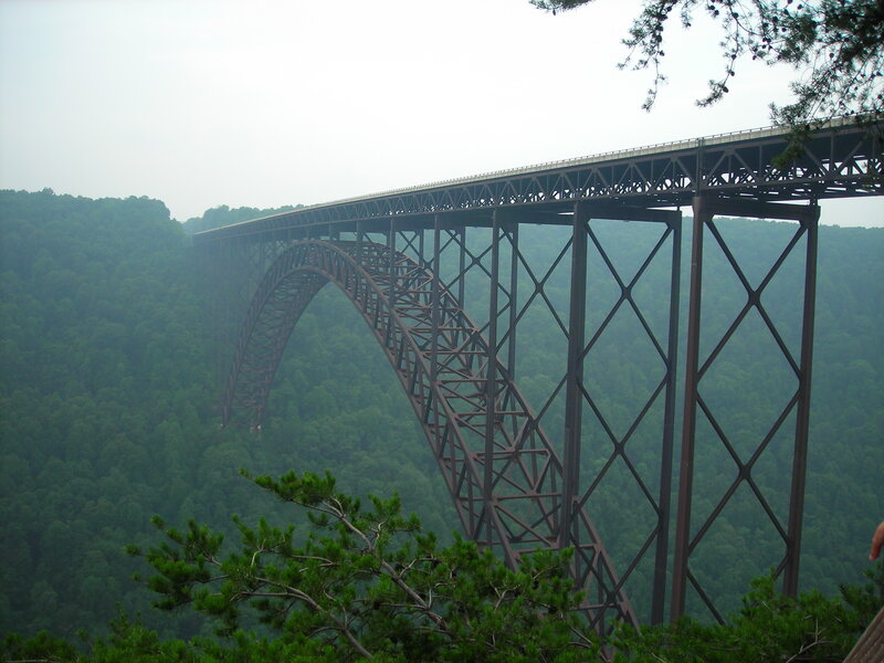 Steel arch bridge over forested valley