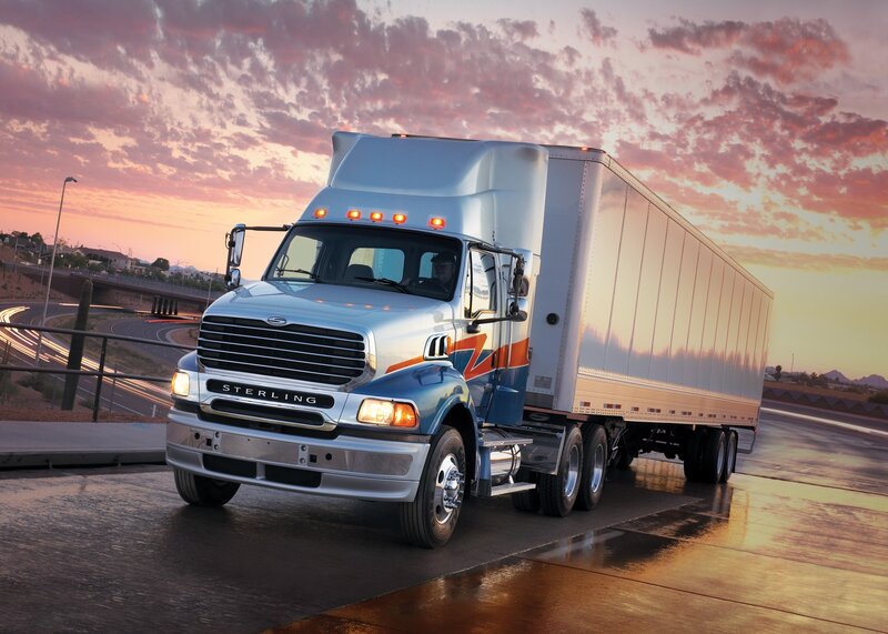Sterling truck on highway at sunset