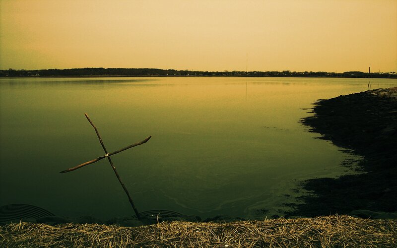 Stick cross by the water