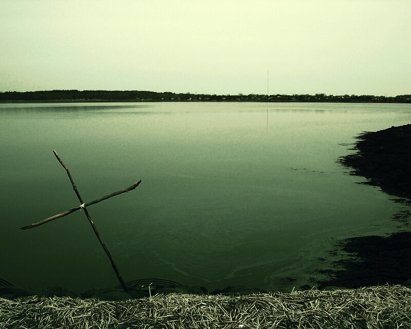 Stick cross by the water