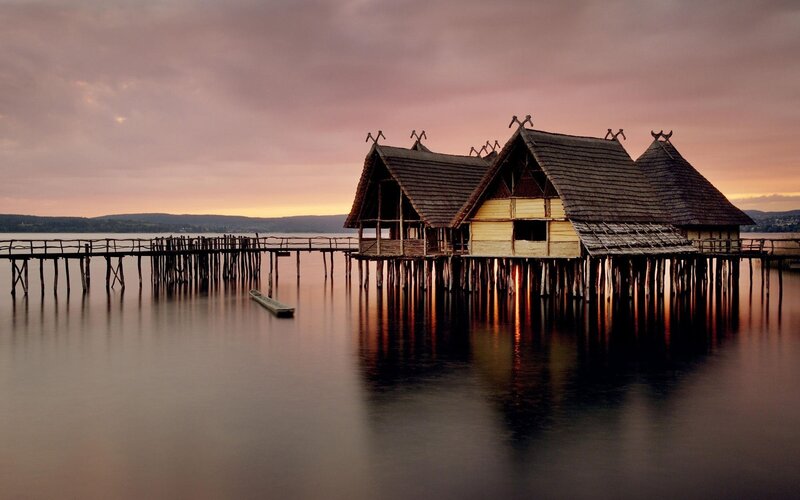 Stilt houses on a lake at sunset