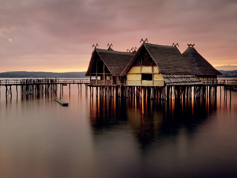 Stilt houses on a lake at sunset