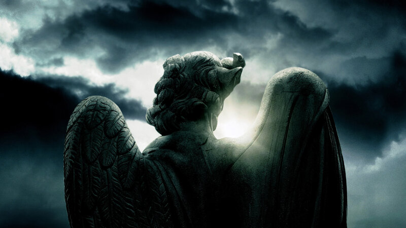 stone angel statue under stormy sky