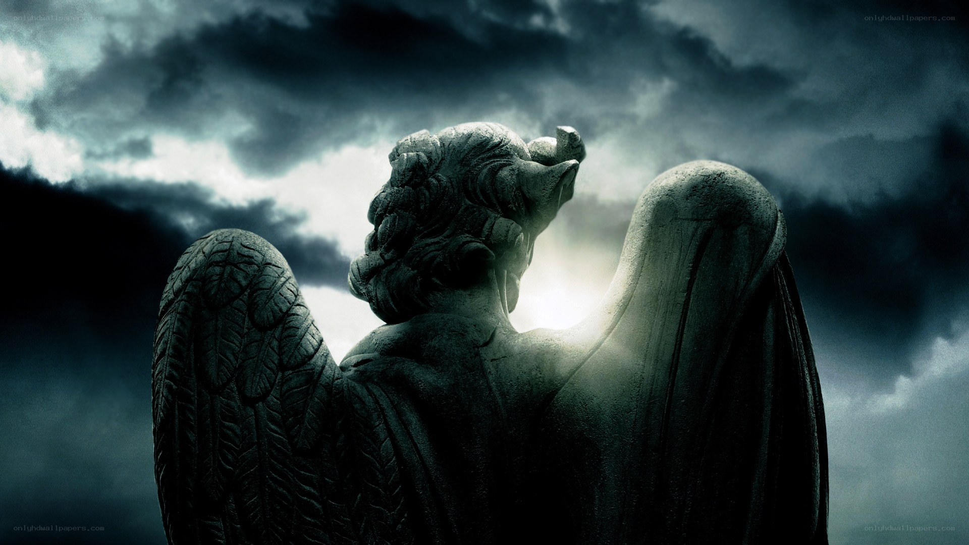 stone angel statue under stormy sky
