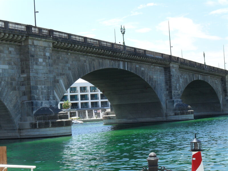 Stone arch bridge over green water