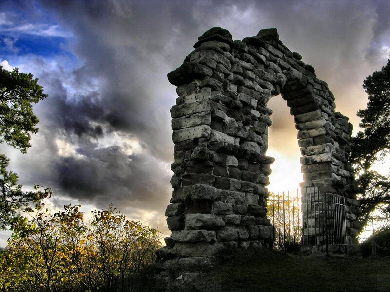 Stone arch ruin under stormy sky