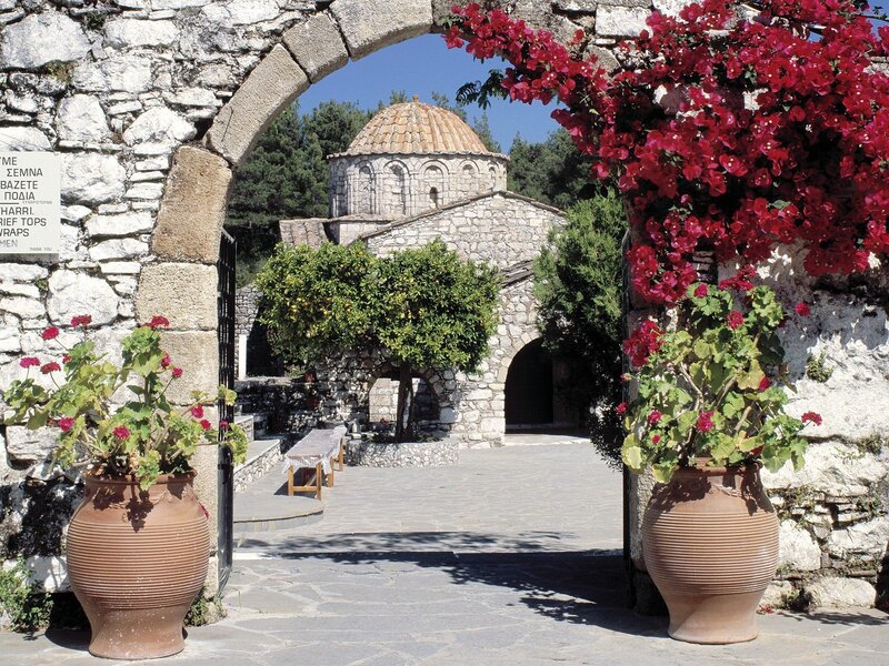Stone archway with flowers and church