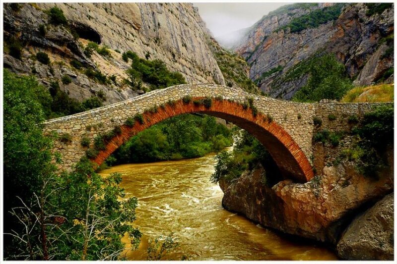 Stone bridge over a river in a canyon