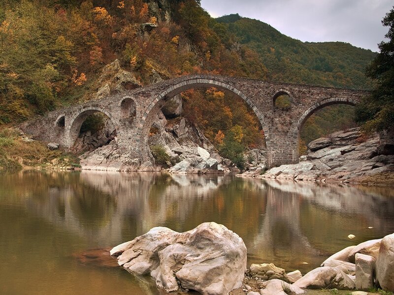 Stone bridge over autumn river