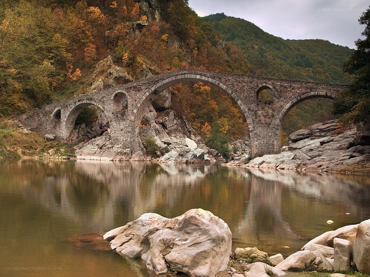 Stone bridge over autumn river