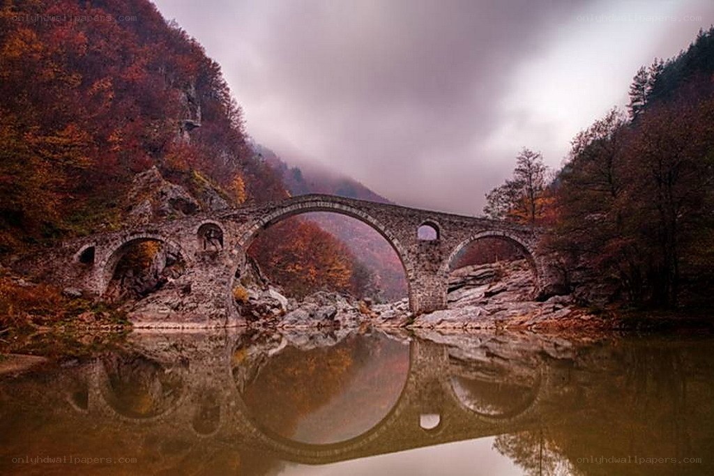 Stone bridge over autumn river