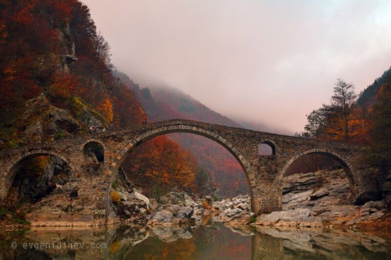 Stone bridge over autumn river