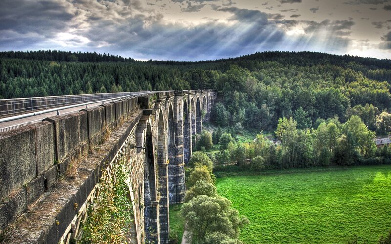 Stone bridge over forested valley