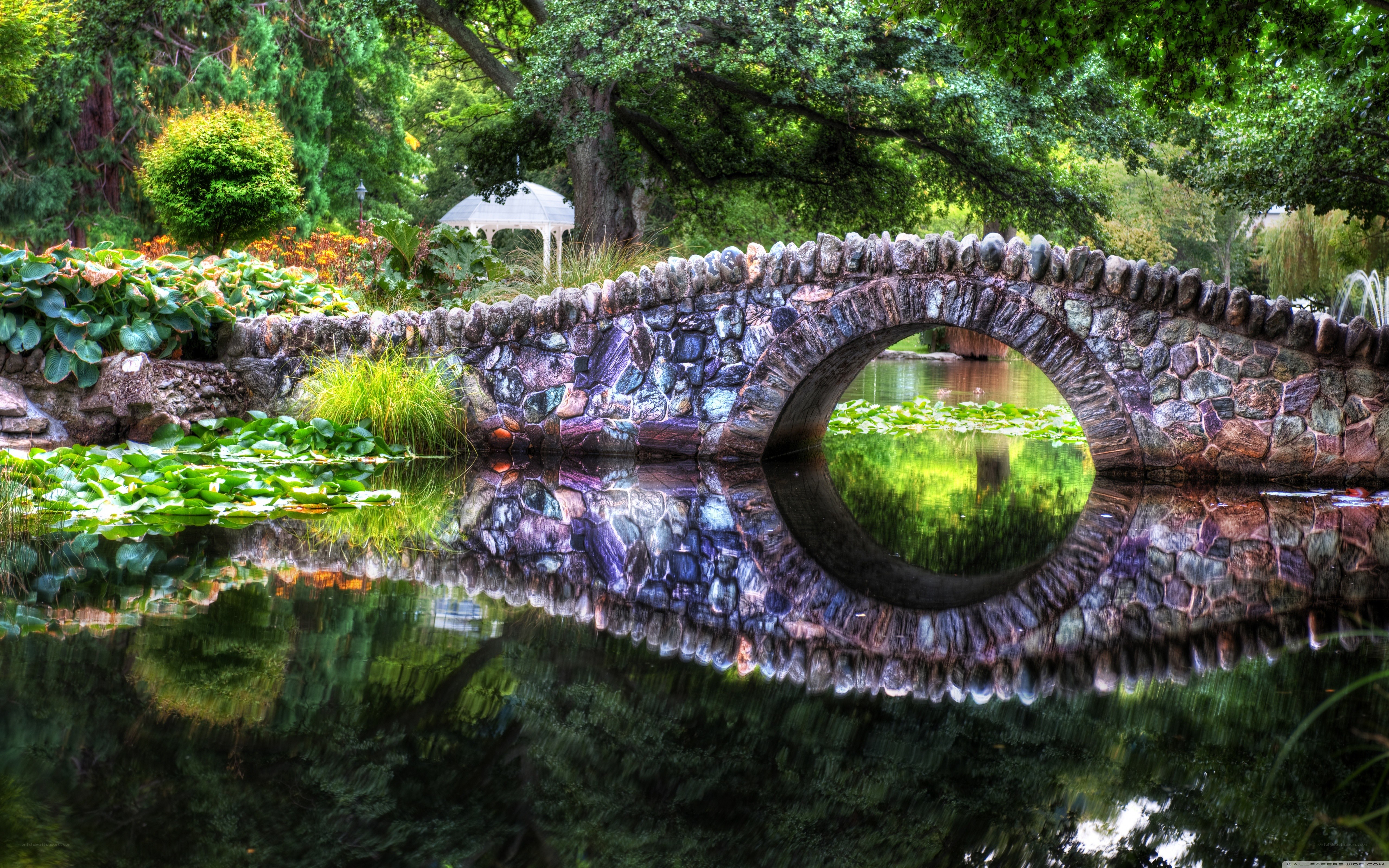 Stone bridge over pond in garden