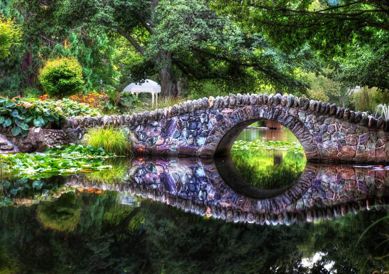 Stone bridge over pond in garden