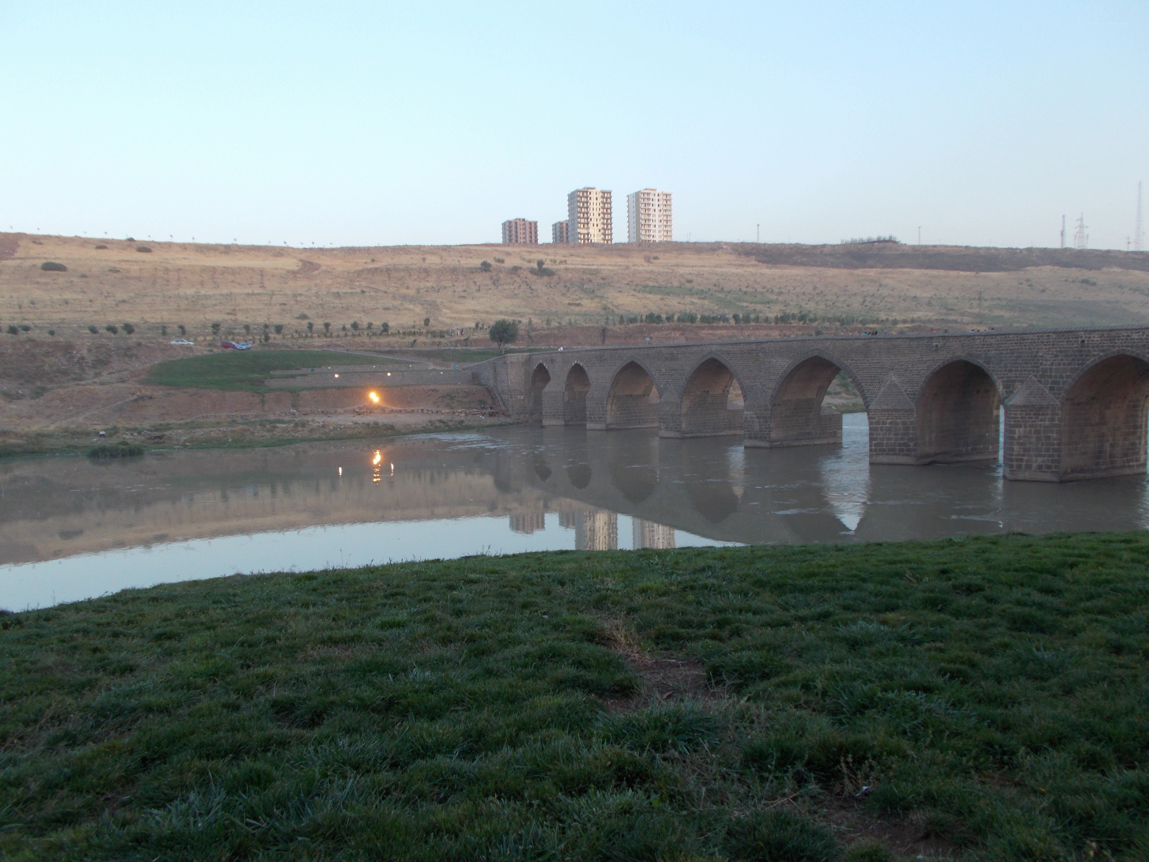 Stone bridge over river at dusk